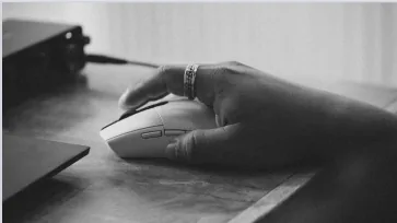 Hand on a computer mouse while working with focus